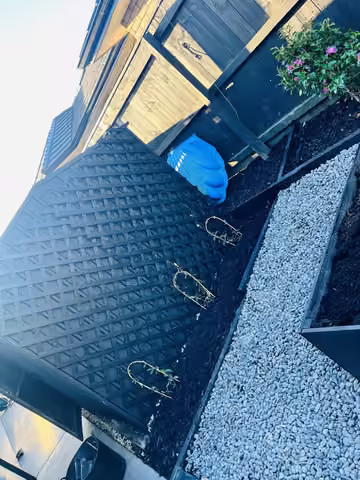 Mulched garden beds and gravel edging beside a house